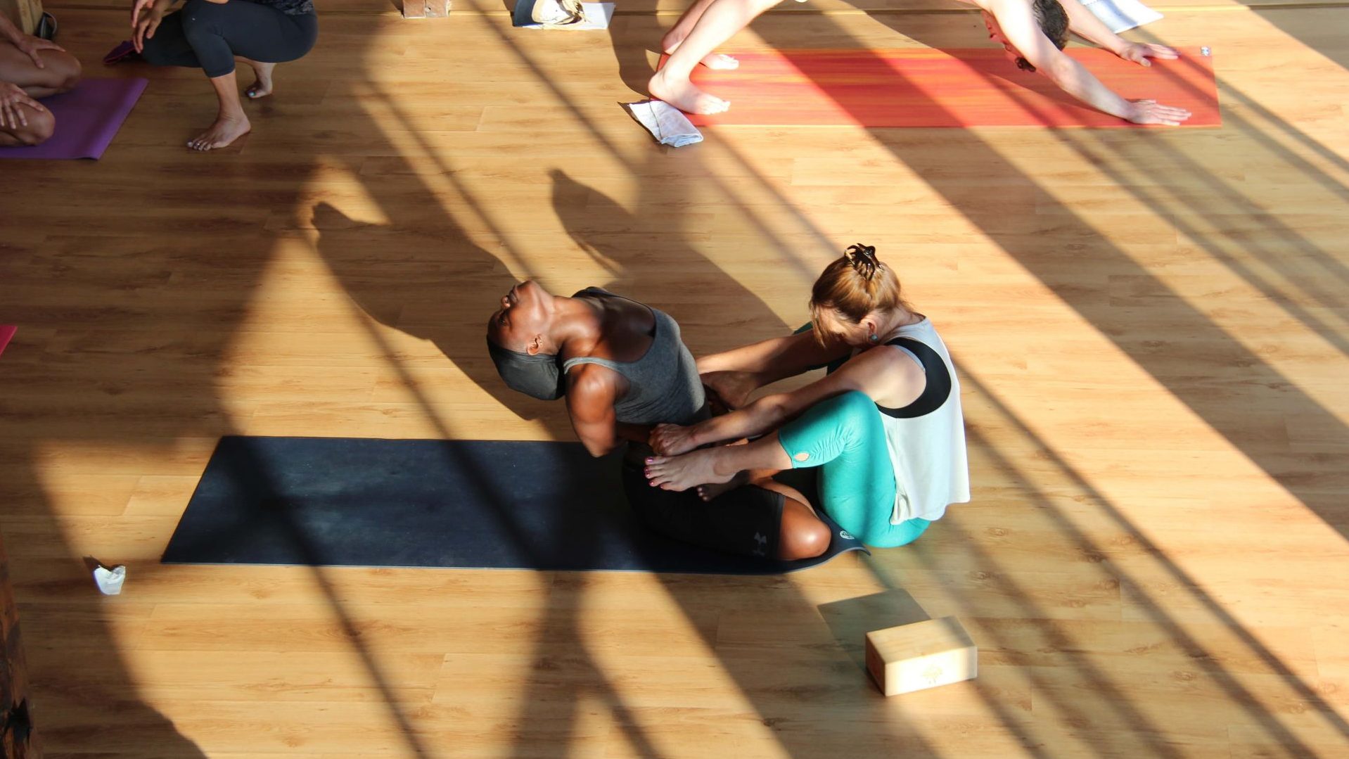 Yoga teacher Valerie giving instructions while a trainee is posing in Bulgaria